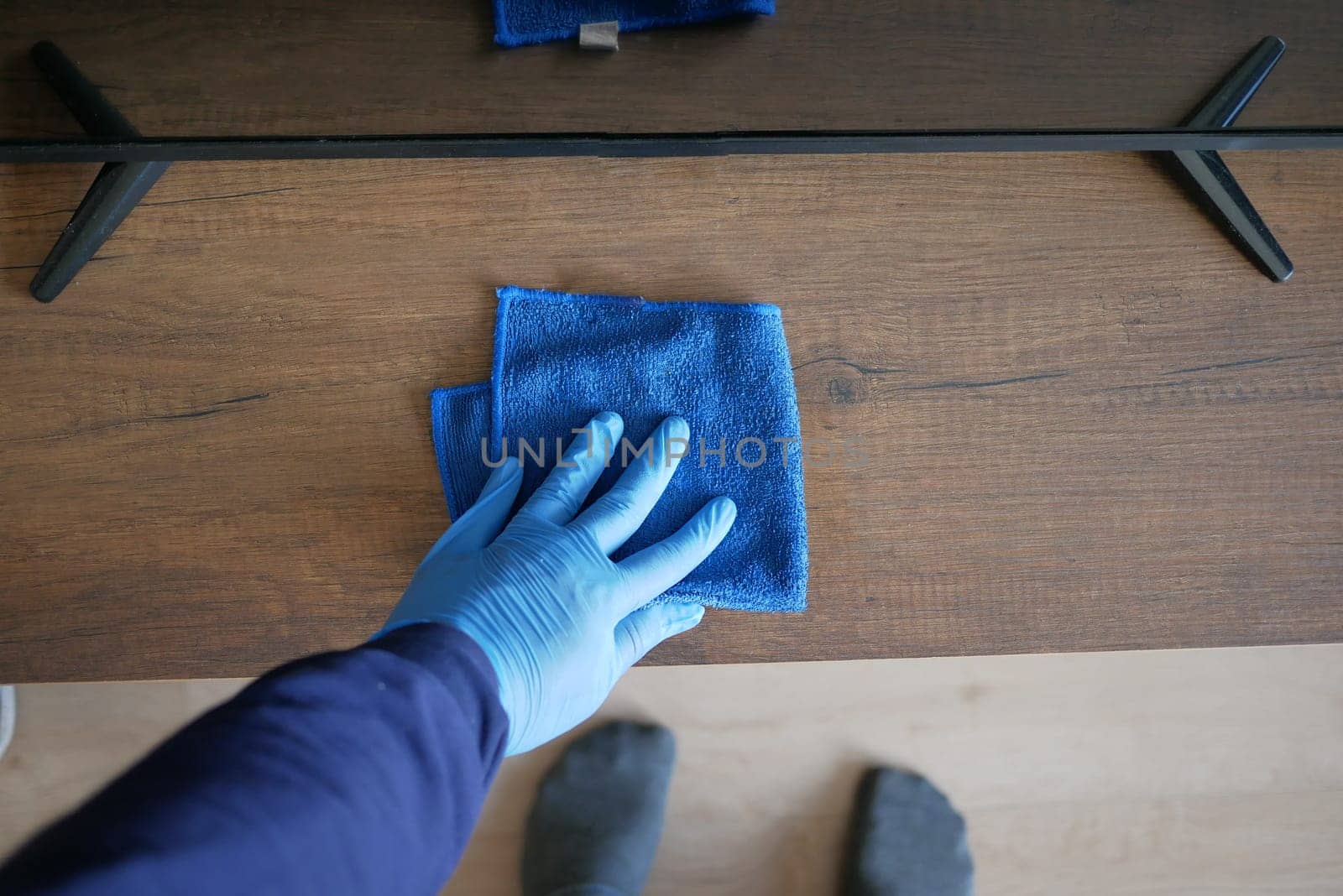 hand holding spray bottle and cleaning table .