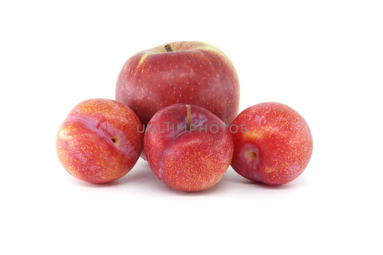 Crimson plums and red apple isolated on white background