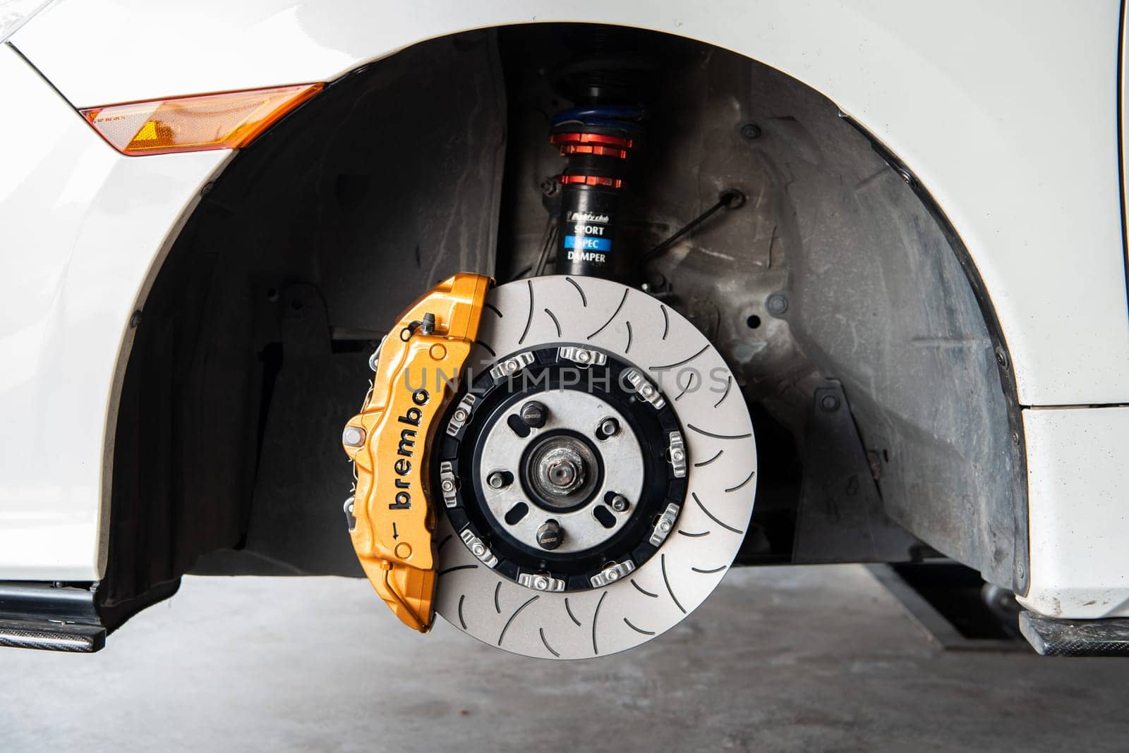 Bangkok, Thailand - February 4, 2023 : Unidentified car mechanic or serviceman disassembly and checking a disc brake and asbestos brake pads for fix and repair problem at car garage or repair shop