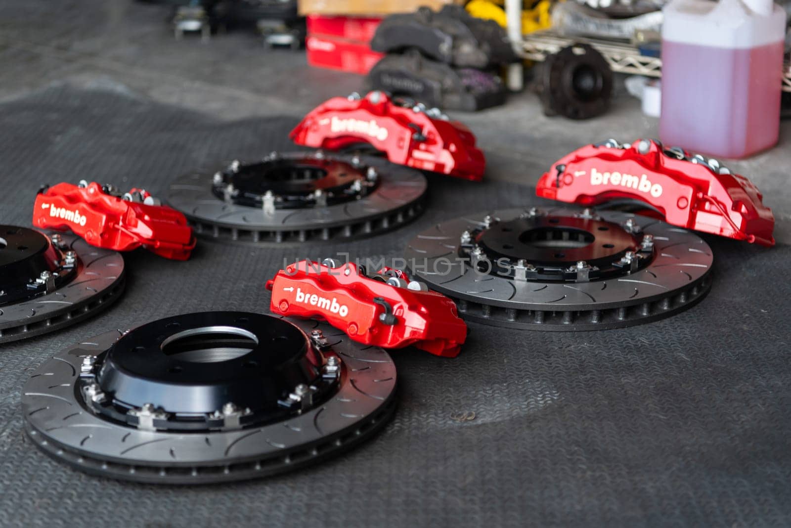 Bangkok, Thailand - February 4, 2023 : Unidentified car mechanic or serviceman disassembly and checking a disc brake and asbestos brake pads for fix and repair problem at car garage or repair shop