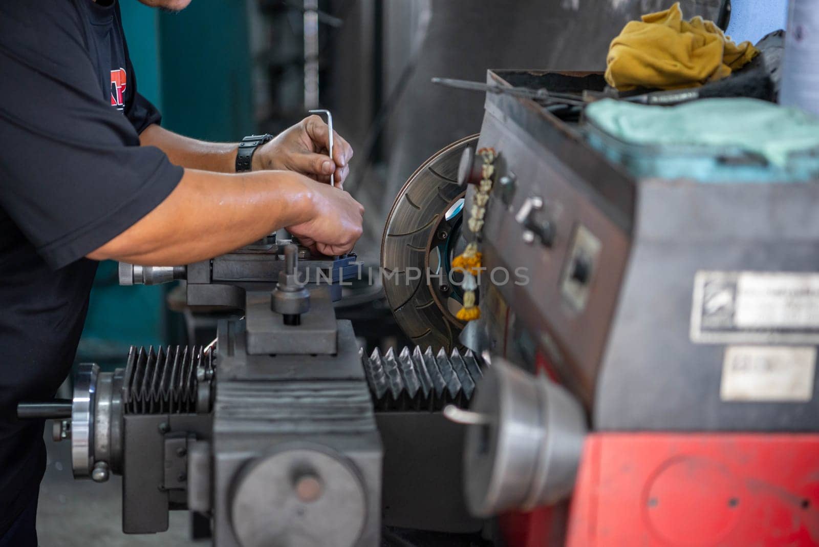 Bangkok, Thailand - February 4, 2023 : Unidentified car mechanic or serviceman disassembly and checking a disc brake and asbestos brake pads for fix and repair problem at car garage or repair shop