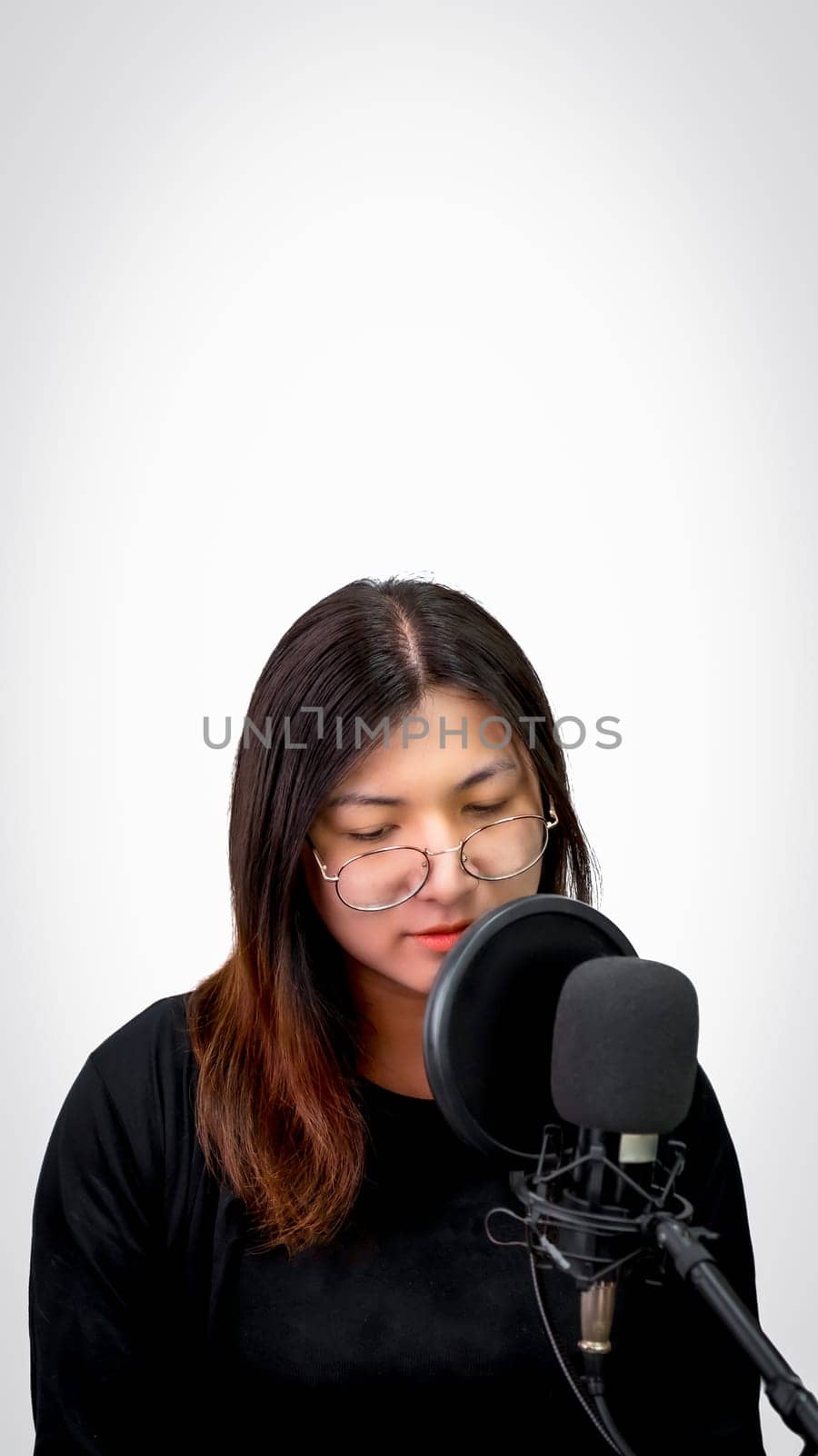 Beautiful asian woman (LGBTQ) is a singer. She enjoying sing a song or karaoke in music studio with microphone condenser and headphones for fun or voice creative