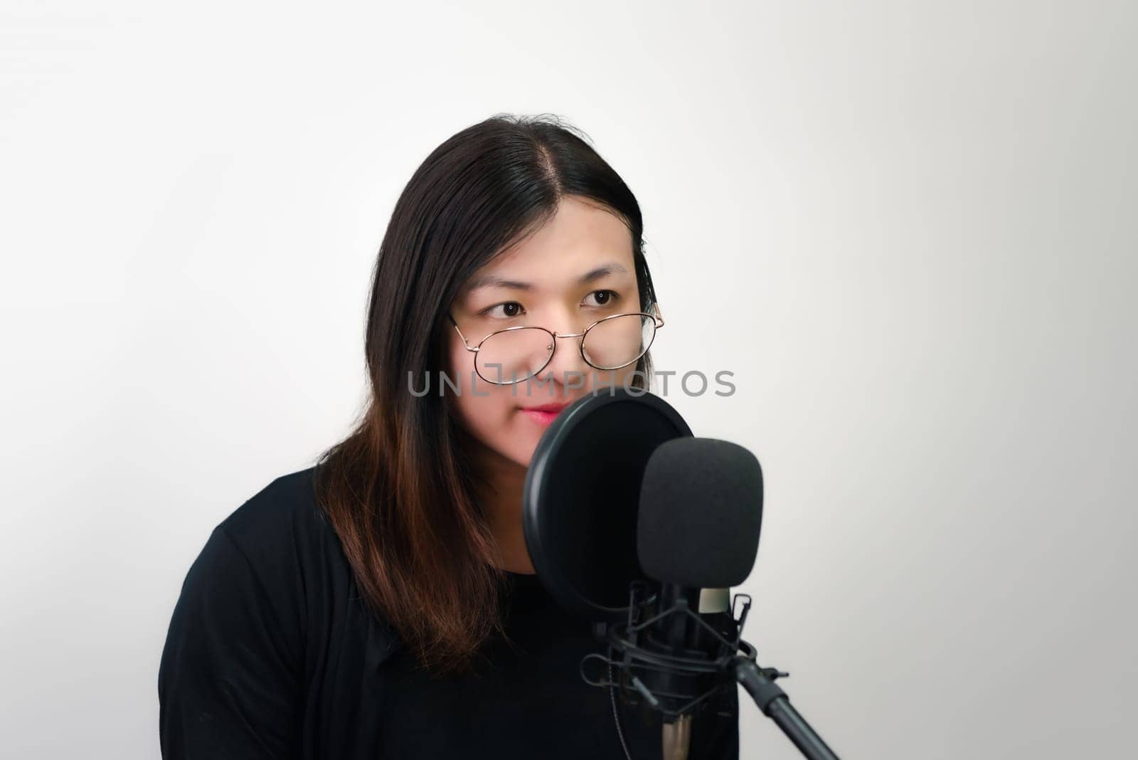 Beautiful asian woman (LGBTQ) is a singer. She enjoying sing a song or karaoke in music studio with microphone condenser and headphones for fun or voice creative