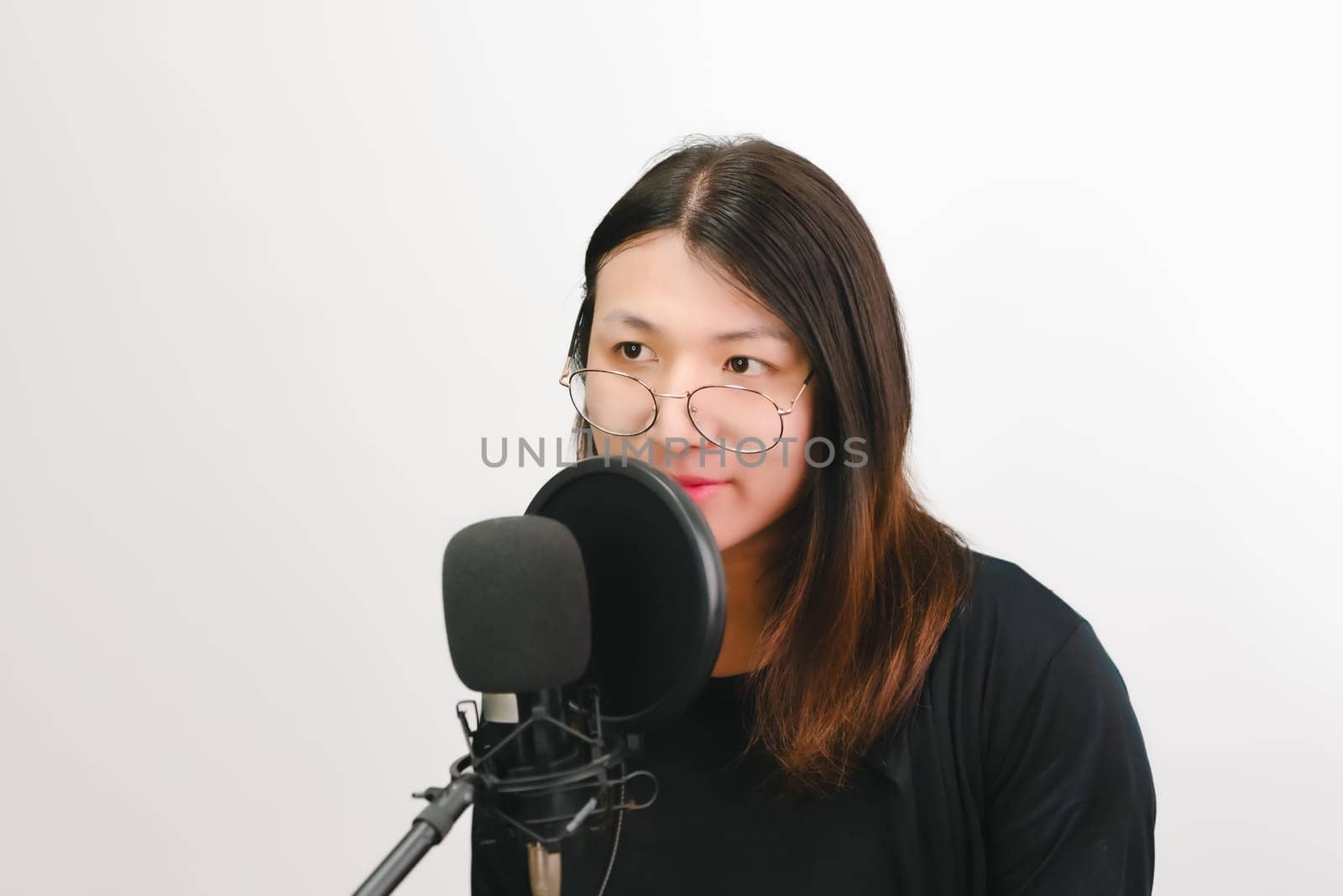 Beautiful asian woman (LGBTQ) is a singer. She enjoying sing a song or karaoke in music studio with microphone condenser and headphones for fun or voice creative