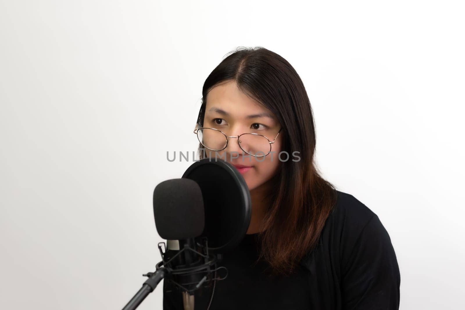 Beautiful asian woman (LGBTQ) is a singer. She enjoying sing a song or karaoke in music studio with microphone condenser and headphones for fun or voice creative