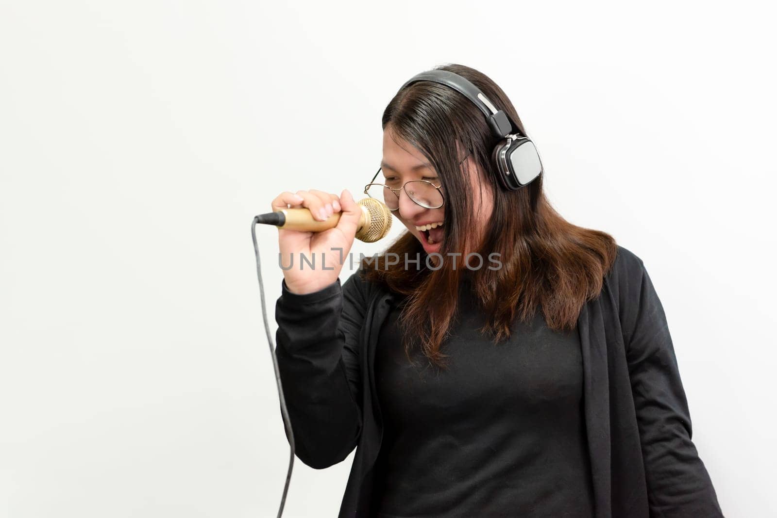 Beautiful asian woman (LGBTQ) is a singer. She enjoying sing a song or karaoke in music studio with microphone condenser and headphones for fun or voice creative