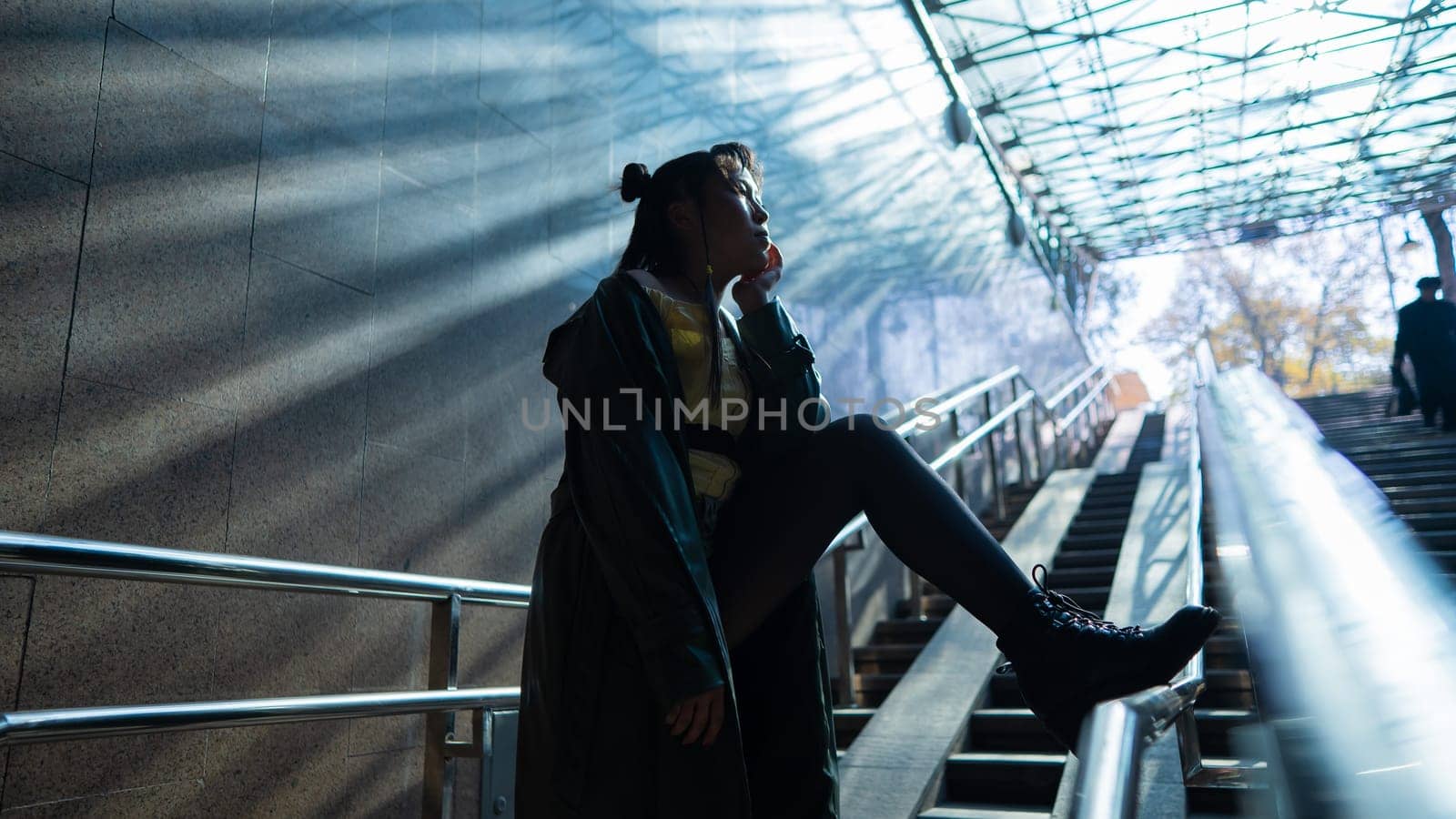 Portrait of a young Asian woman posing in the subway near the stairs. by mrwed54