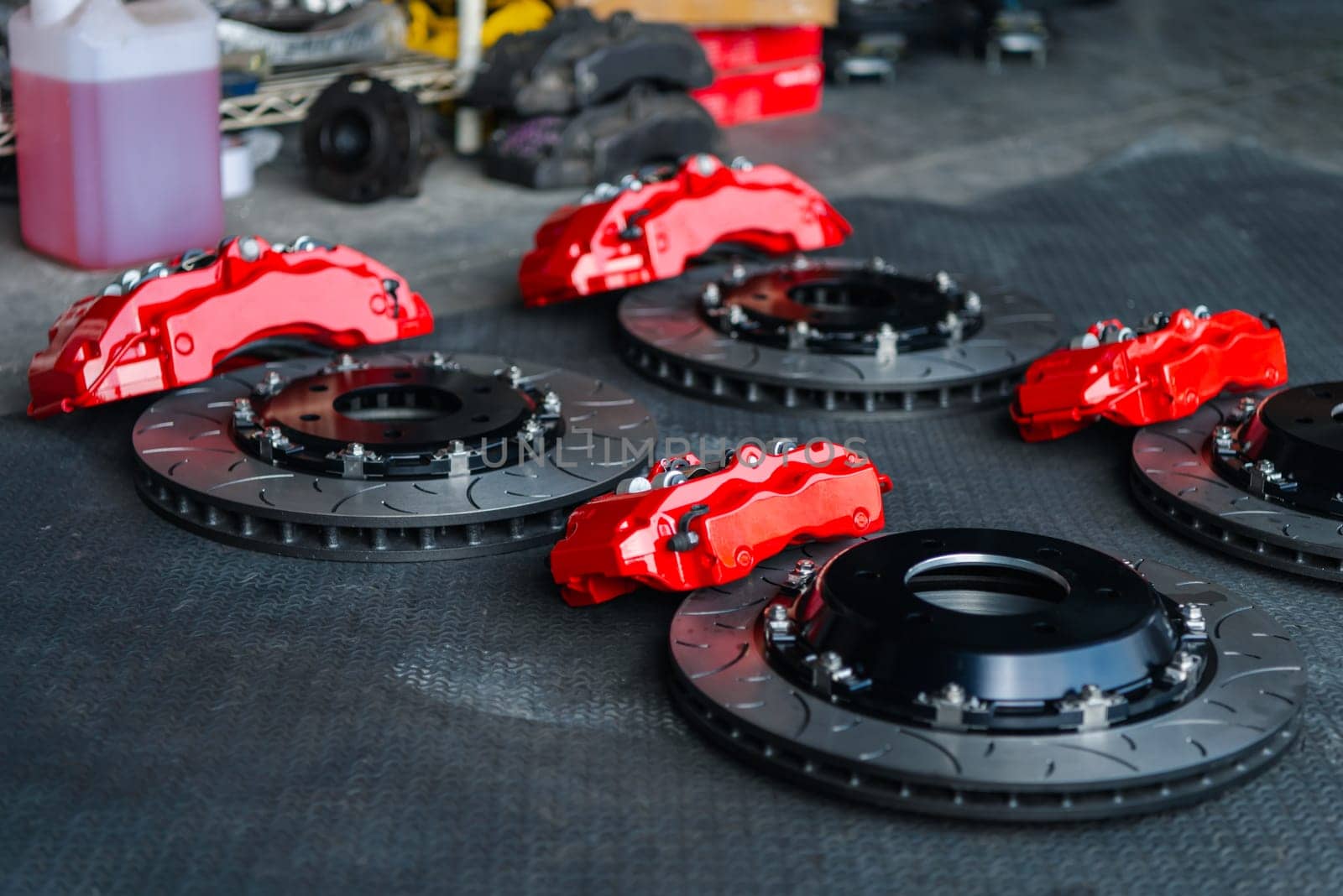 Car mechanic or serviceman disassembly and checking a disc brake and asbestos brake pads for fix and repair problem at car garage or repair shop