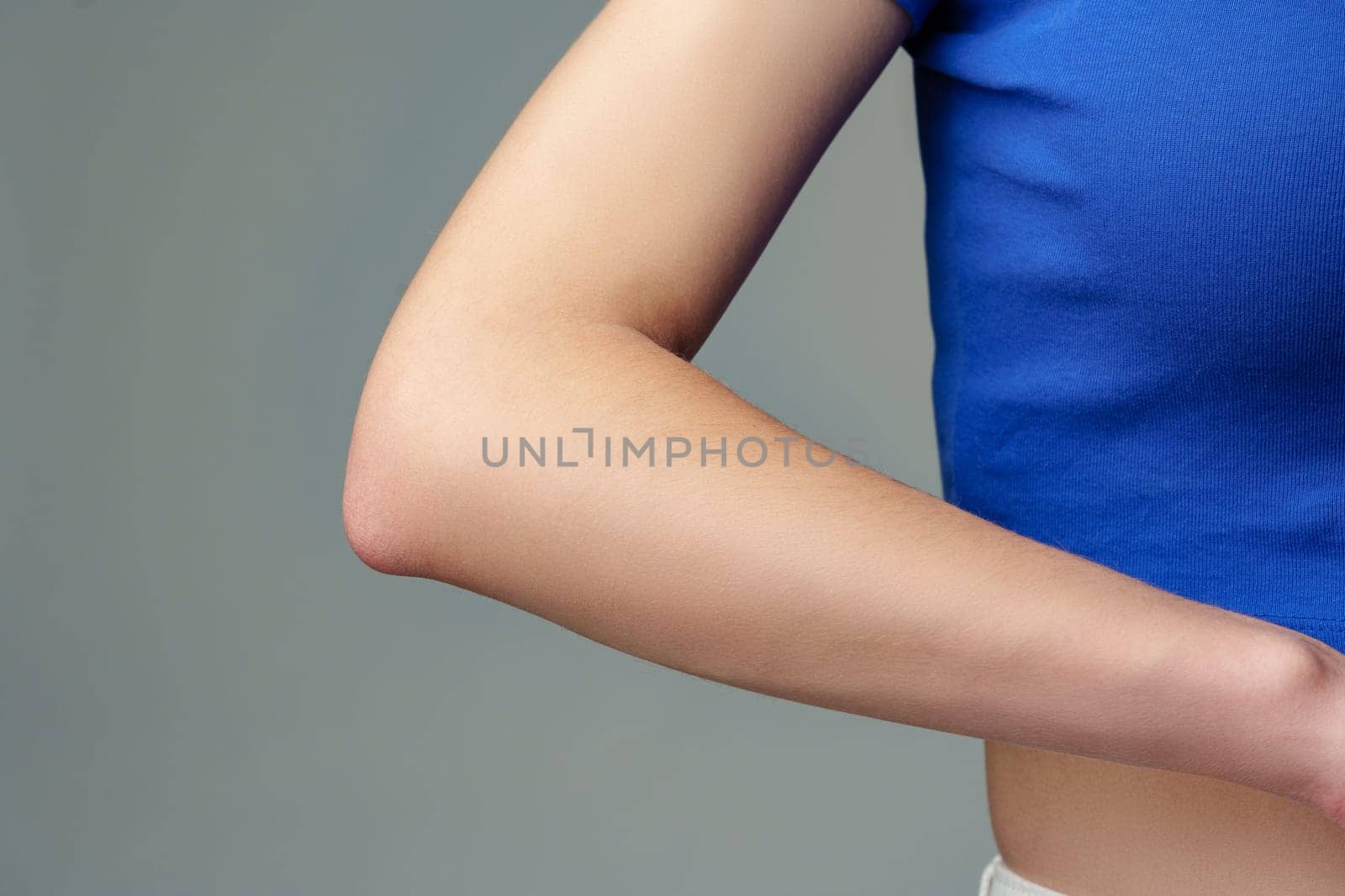 Closeup of a beautiful woman elbow on gray background in studio