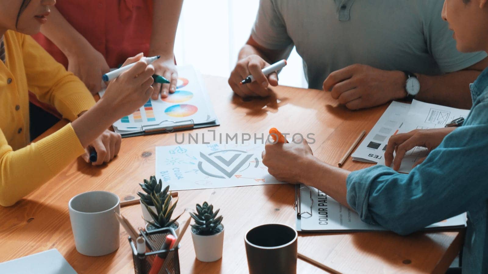 Top aerial view of business people working together to choosing color from color palette. Manager present idea by using tablet to marketing team while business man looking at logo graphic. Symposium.