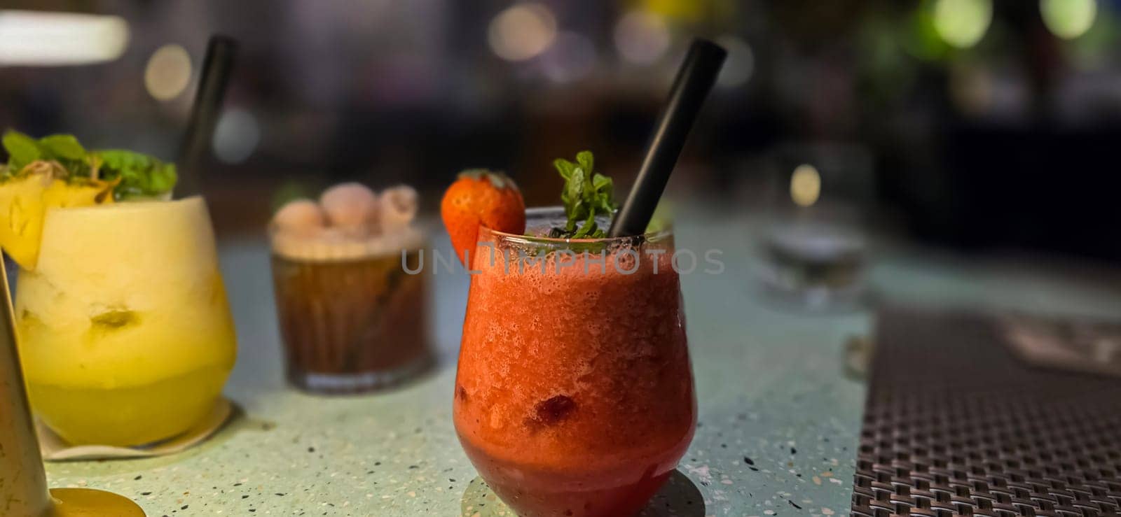Fruit cocktail smoothie diet detox, tropical fruit summer cocktail with garnish, and ice on restaurant background by antoksena