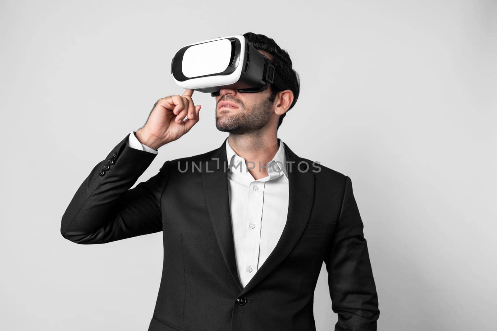 Caucasian business man planning financial plan while using VR goggle. Professional project manager standing and touching VR headset while using visual reality glasses to connect metaverse. Deviation.