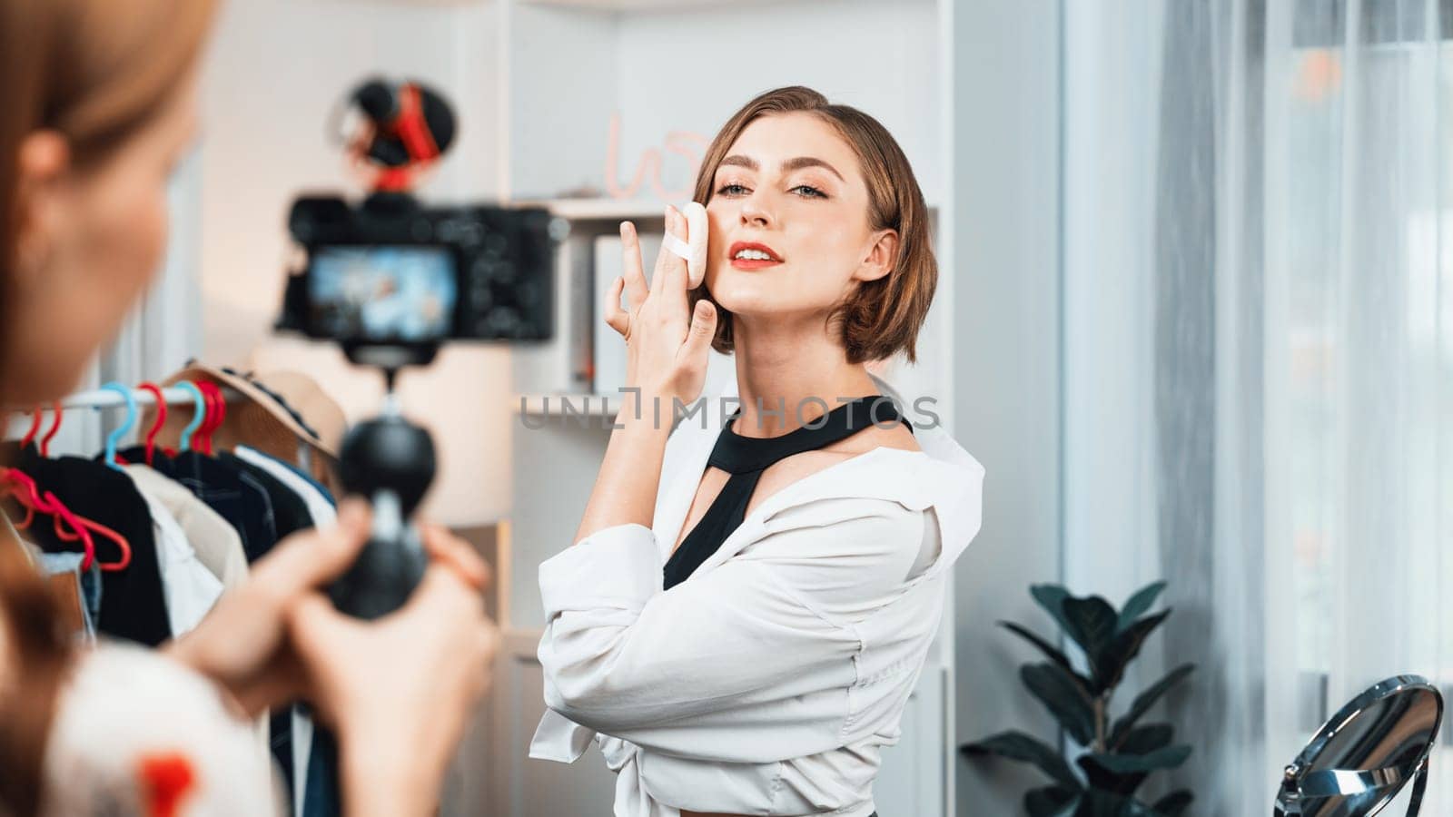 Woman influencer shoot live streaming vlog video review makeup utmost social media or blog. Happy young girl with cosmetics studio lighting for marketing recording session broadcasting online.