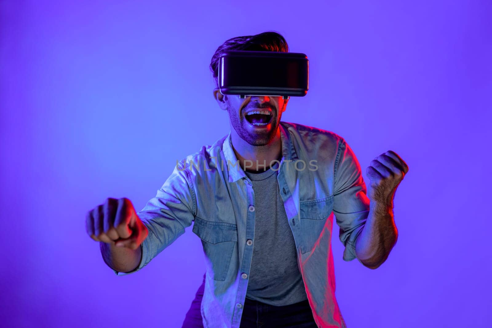 Smart man wear virtual goggle while move driving car hand gesture. Caucasian teenager using futuristic digital technology to enter virtual world while standing at colorful neon background. Deviation.