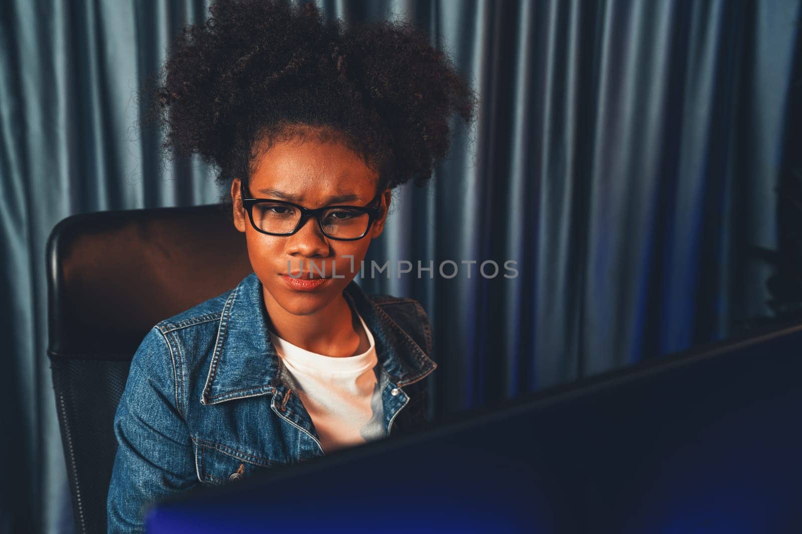 Young African American creator woman with serious face, thinking carefully and looking at final project document on laptop for planing next sequence. Concept of work at neat home place. Tastemaker.