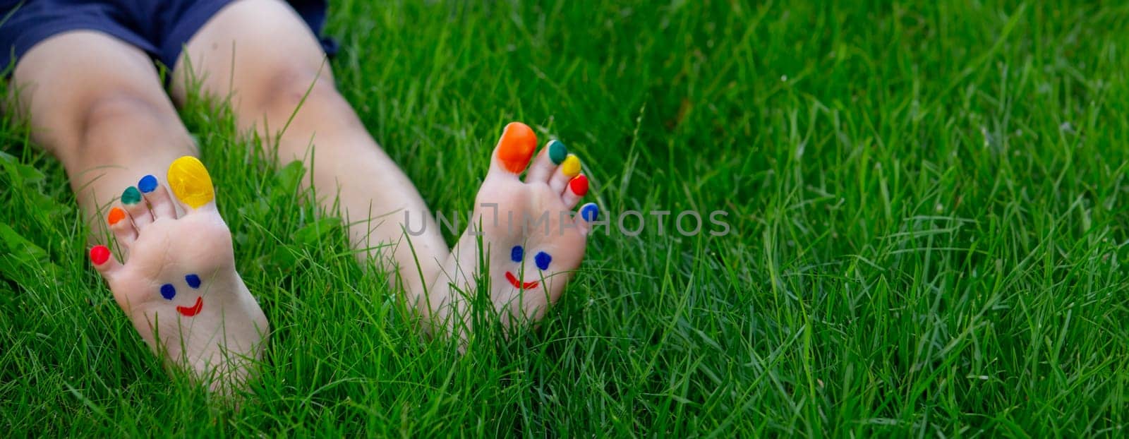 a smile drawn with paints on a child's legs.