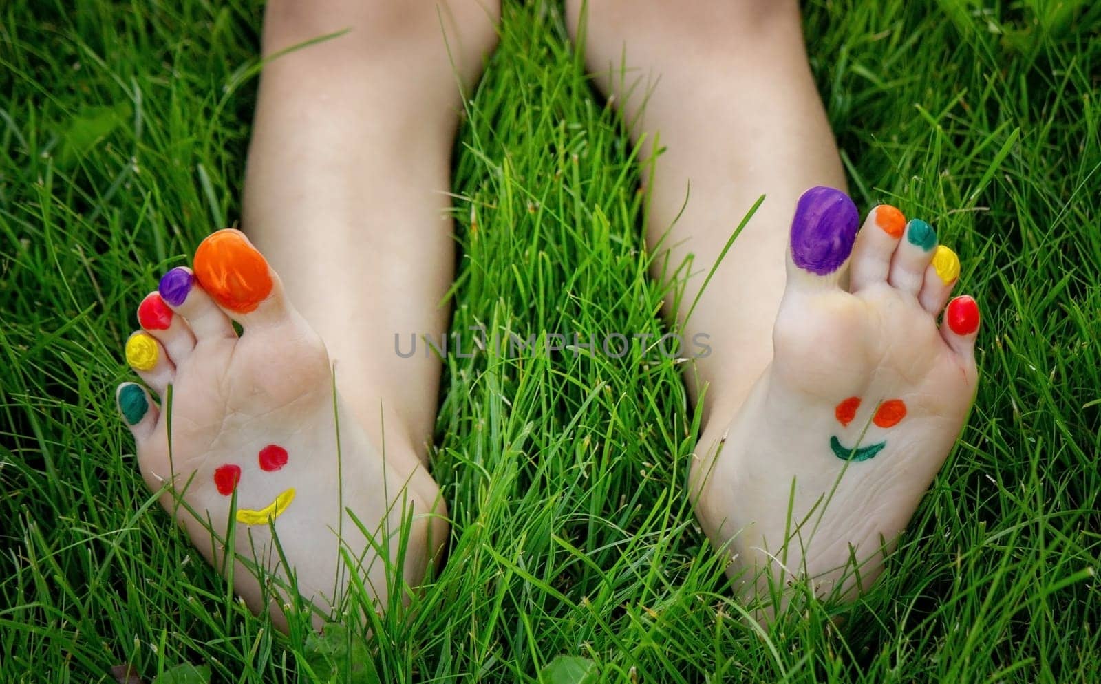 a smile drawn with paints on a child's legs.