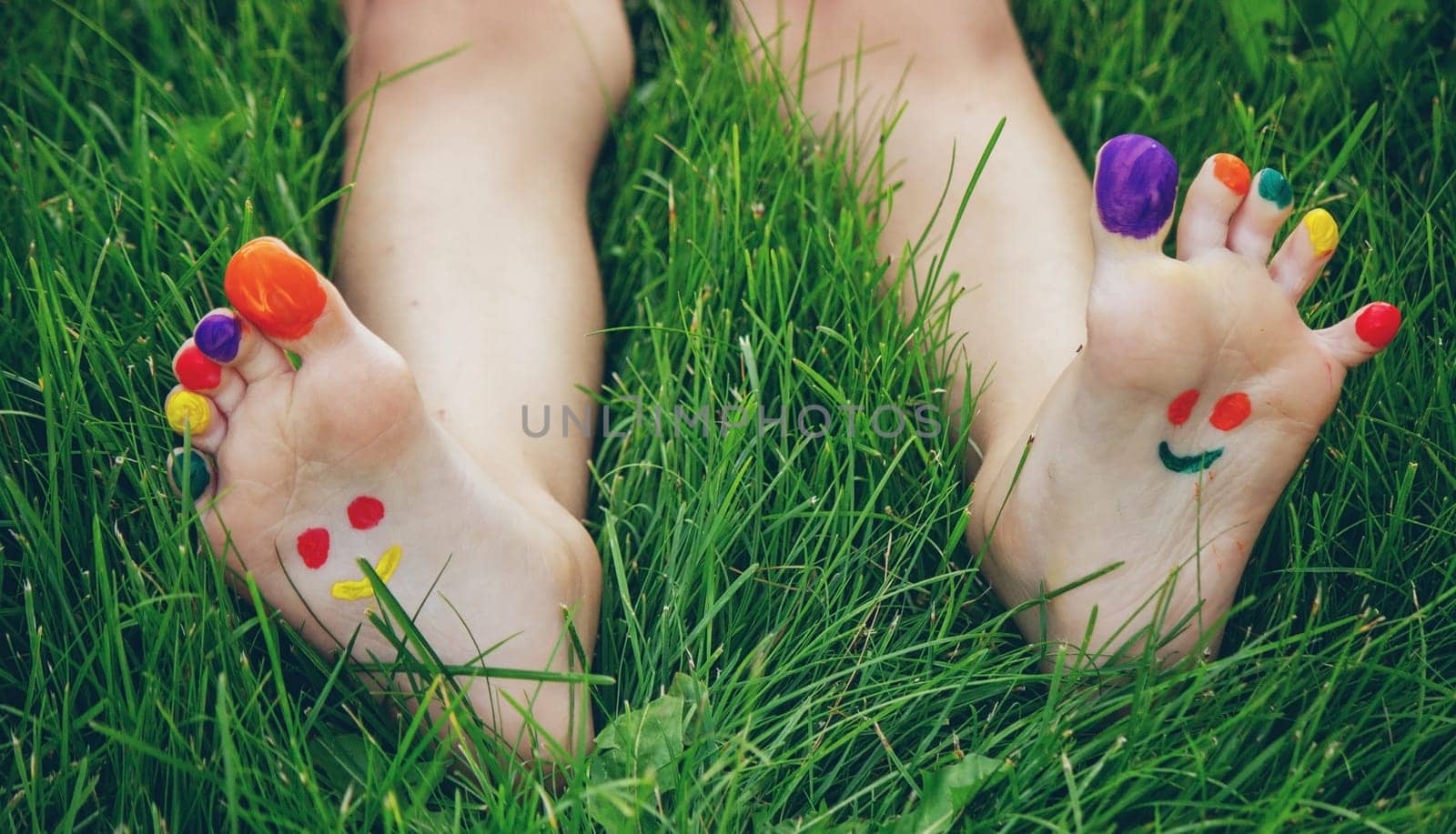 a smile drawn with paints on a child's legs.