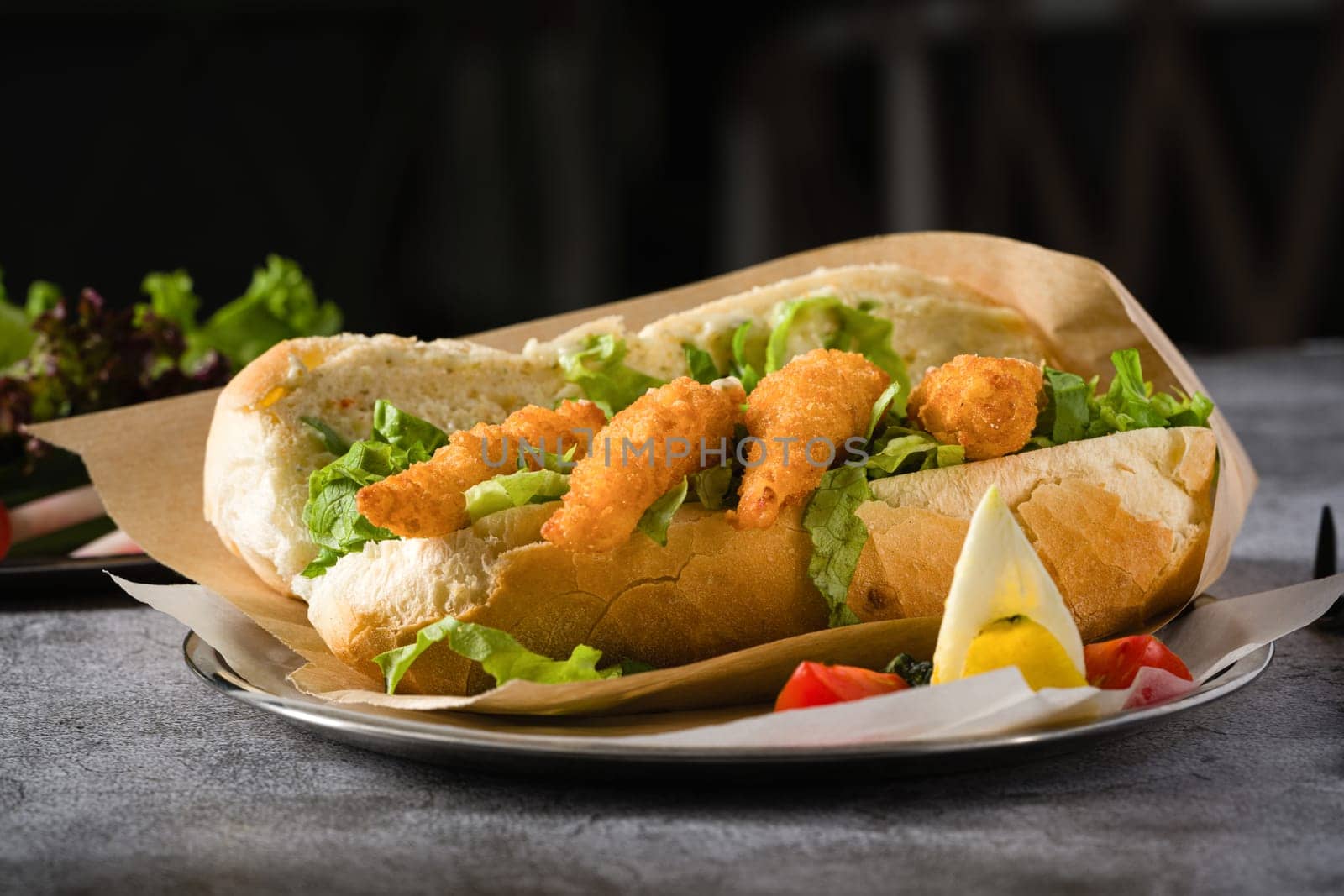 Deep fried shrimp in bread with greens on the side. Shrimp sandwich