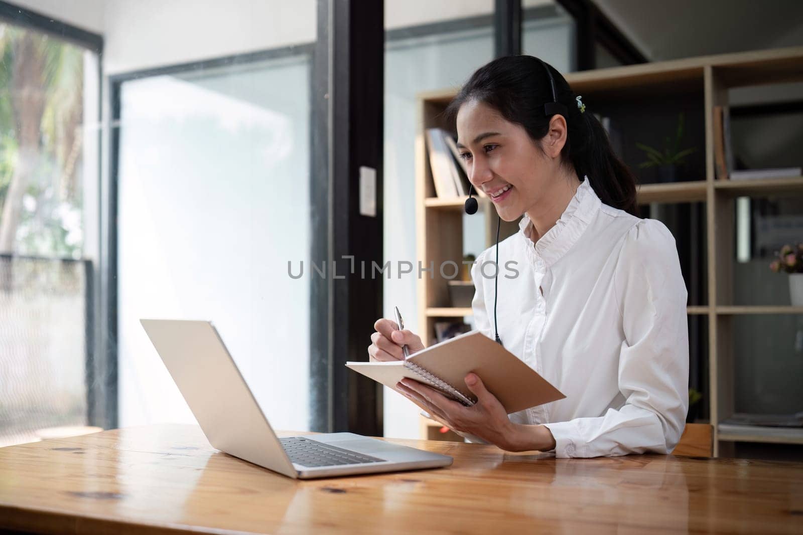 Call center agent with headset working on support hotline in office. Video conference.