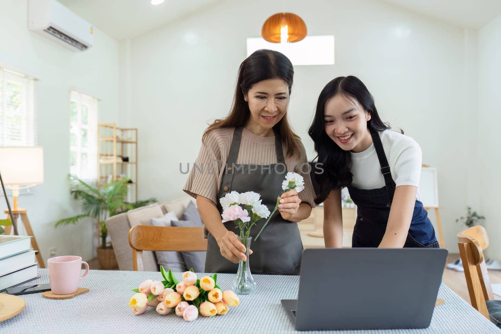 Mother and daughter arrange flower together at home on the weekend, family activities, mother and daughter do activities together on Mother's Day.