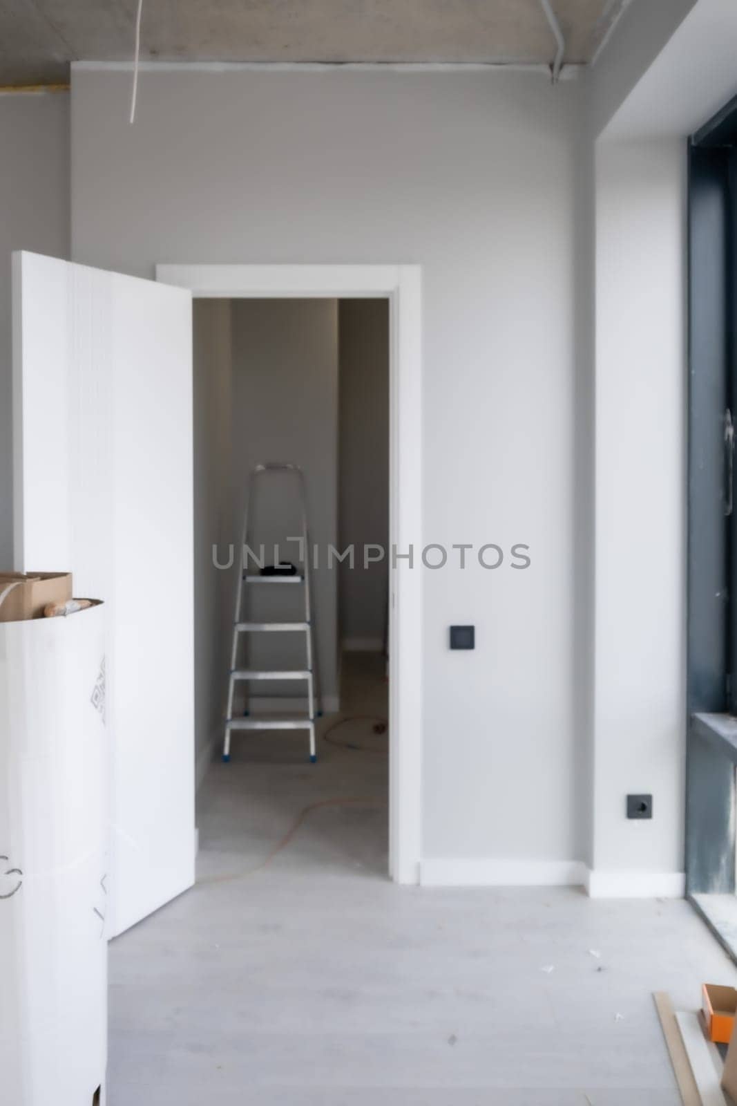 An open white door with a manual one in a renovated apartment. by AnatoliiFoto