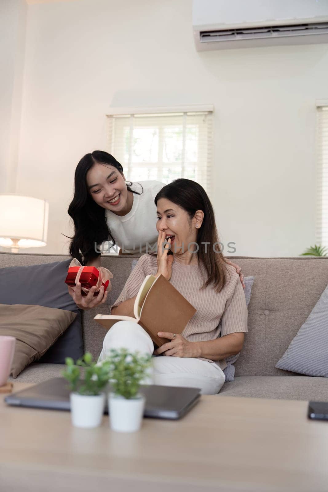 Happy mother day. Beautiful young daughter woman and mother with gift box at home.