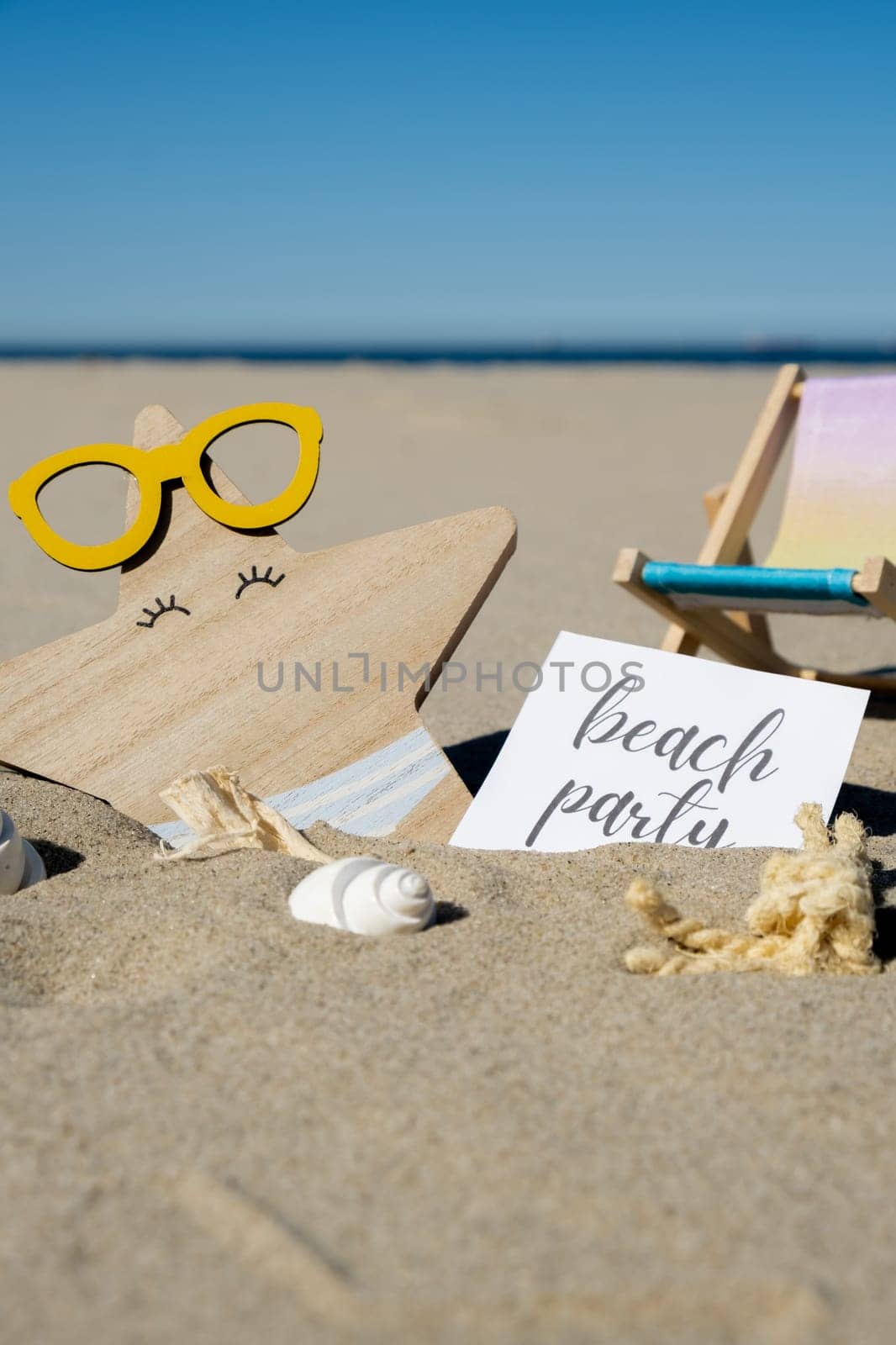 BEACH PARTY text on paper greeting card on background of beach chair lounge starfish summer vacation decor. Sandy beach sun. Holiday concept postcard. Travel Business concept