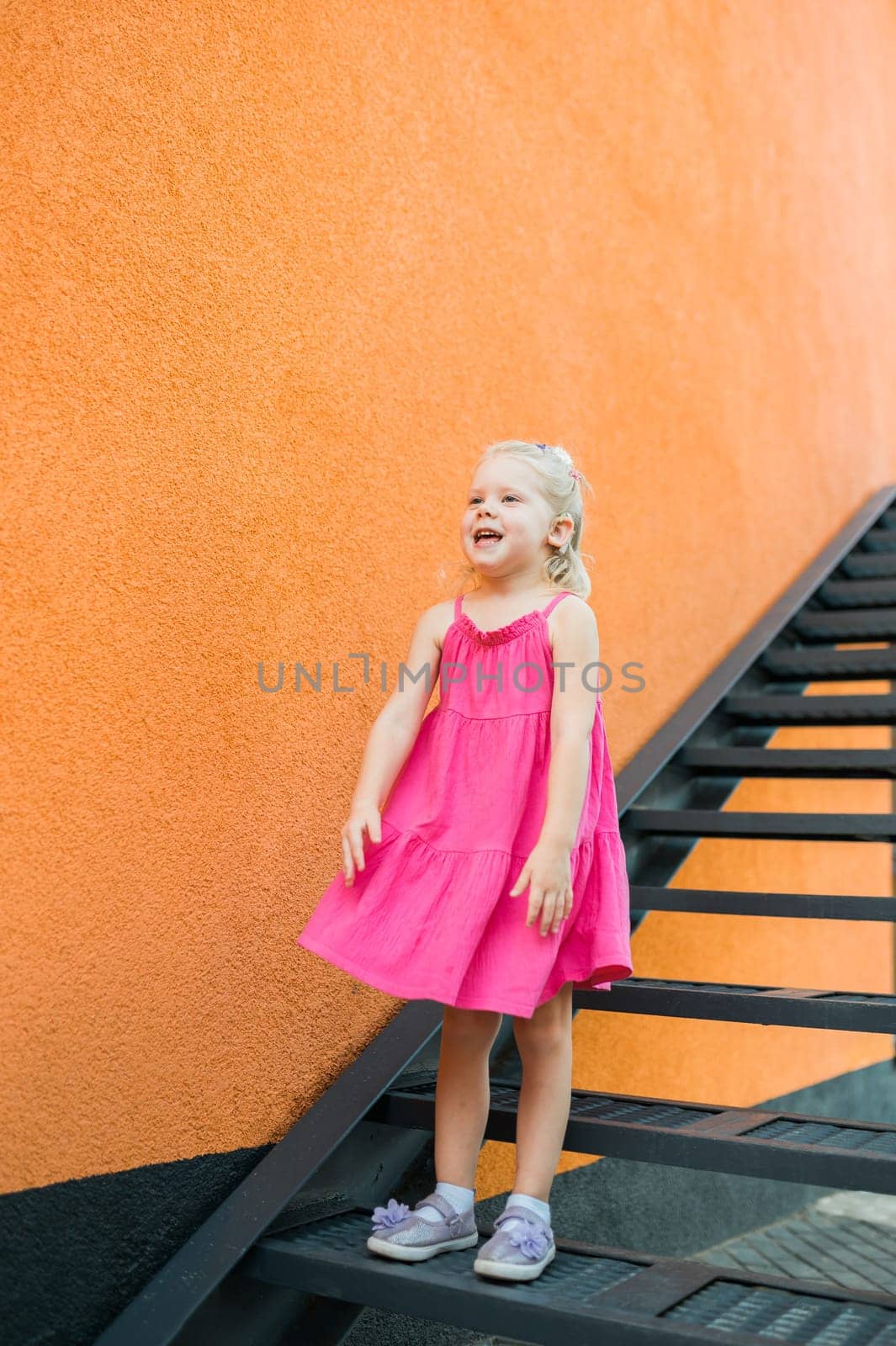 Child girl walks and have fun outdoor with cochlear implant on the head. Hearing aid and treatment concept. Copy space vertical.