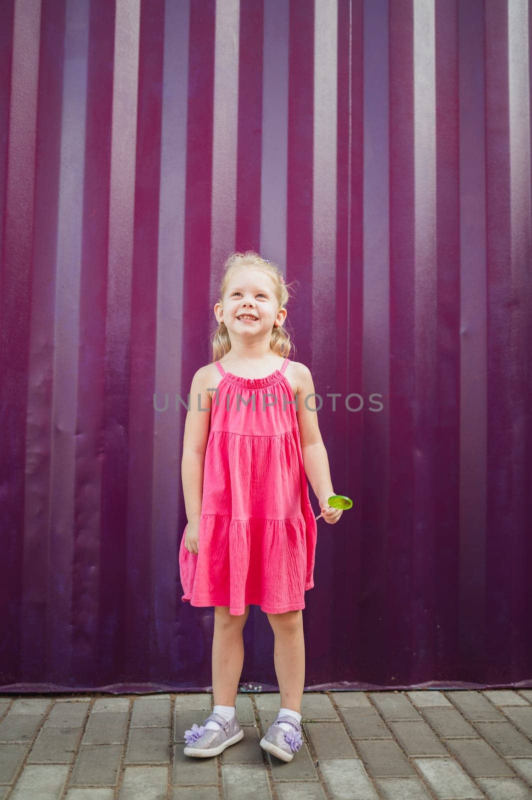 Child girl walks and have fun outdoor with cochlear implant on the head. Hearing aid and treatment concept. Copy space vertical.