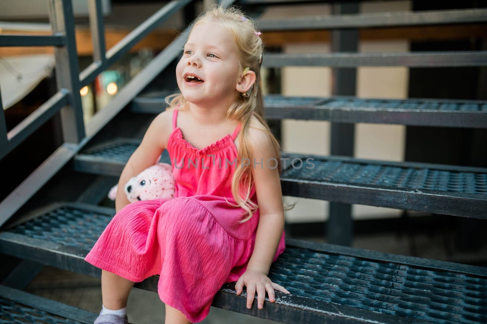 Child with hearing problem and cochlear implant dance in street, deaf kid began to hear. Hearing loss in childhood and treatment concept. Copy space and empty place for text.