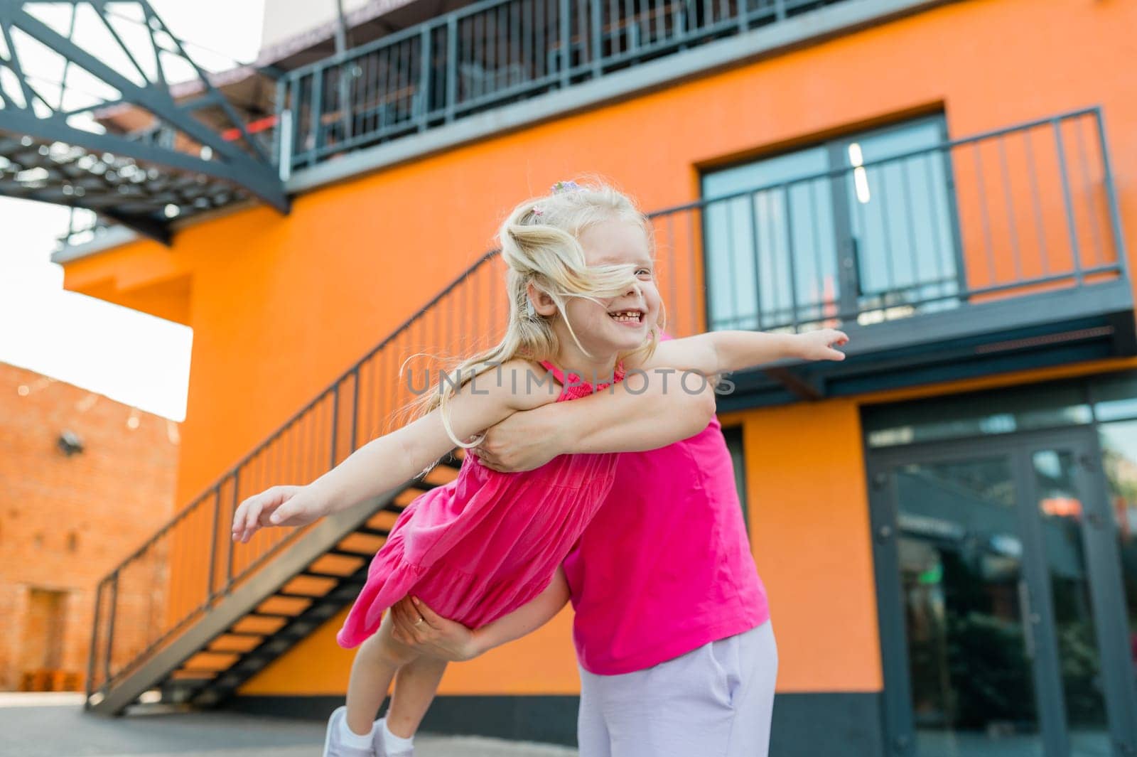 Deaf child with cochlear implant for hearing audio and aid for impairment having fun and laughs with mother outdoor in summer. Sound fitting device to help with communication listening and interaction. Copy space. Inclusion by Satura86