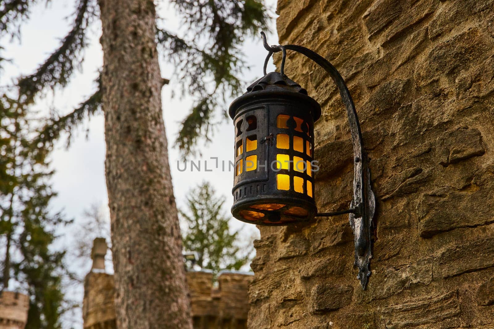 Vintage lantern on a stone wall at Bishop Simon Brute College, Indiana, casting a warm glow amidst a tranquil, rustic setting