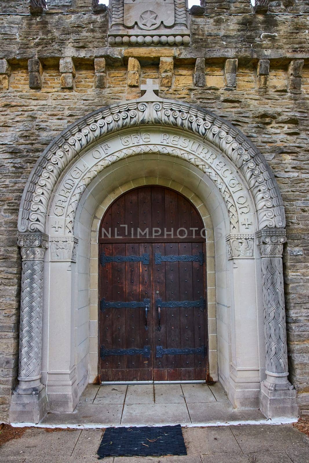 Daytime view of the grand, intricately carved entrance to the historic Bishop Simon Brute College Chapel in Indianapolis, echoing timeless religious reverence and architectural majesty.