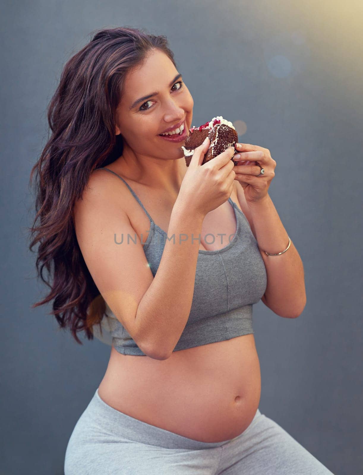 Pregnant woman, cake and portrait in studio for craving dessert, maternity and prenatal overeating in pregnancy. Mother, smile and belly isolated with sweet confection for eat, sugar or treats.