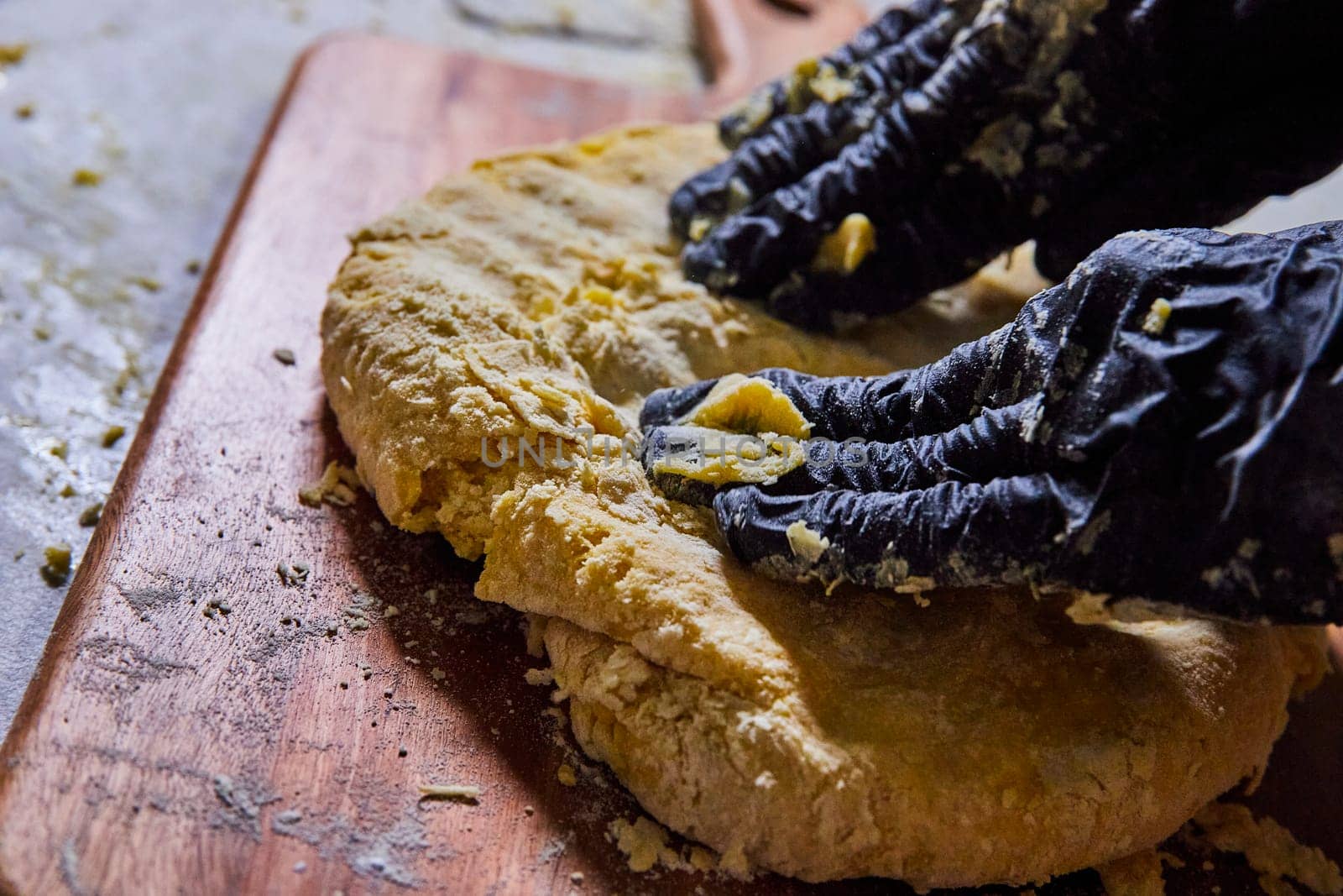Gloved hands gently break apart a golden homemade rustic bread loaf, Fort Wayne, Indiana's bakery scene