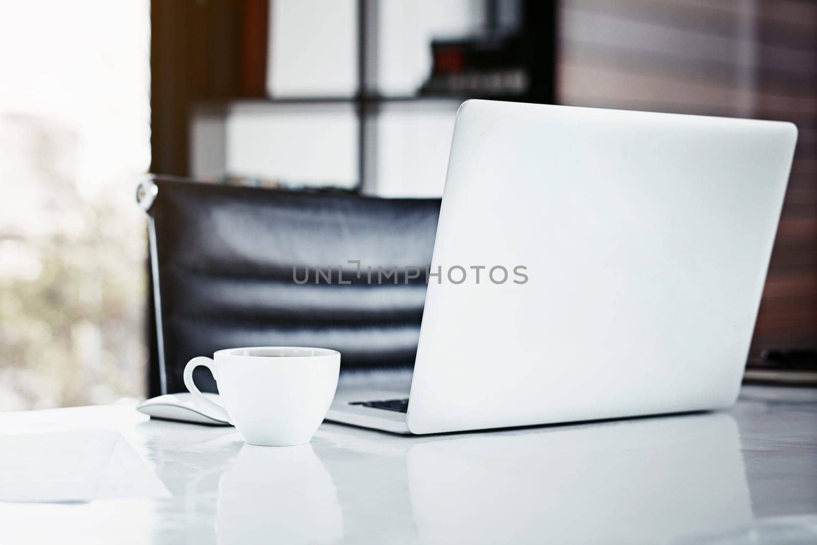 Empty office, desk and laptop or coffee for interior design, internet and minimal trend in workplace. Mug, tech and online for project or networking via email, planning and research on website by YuriArcurs