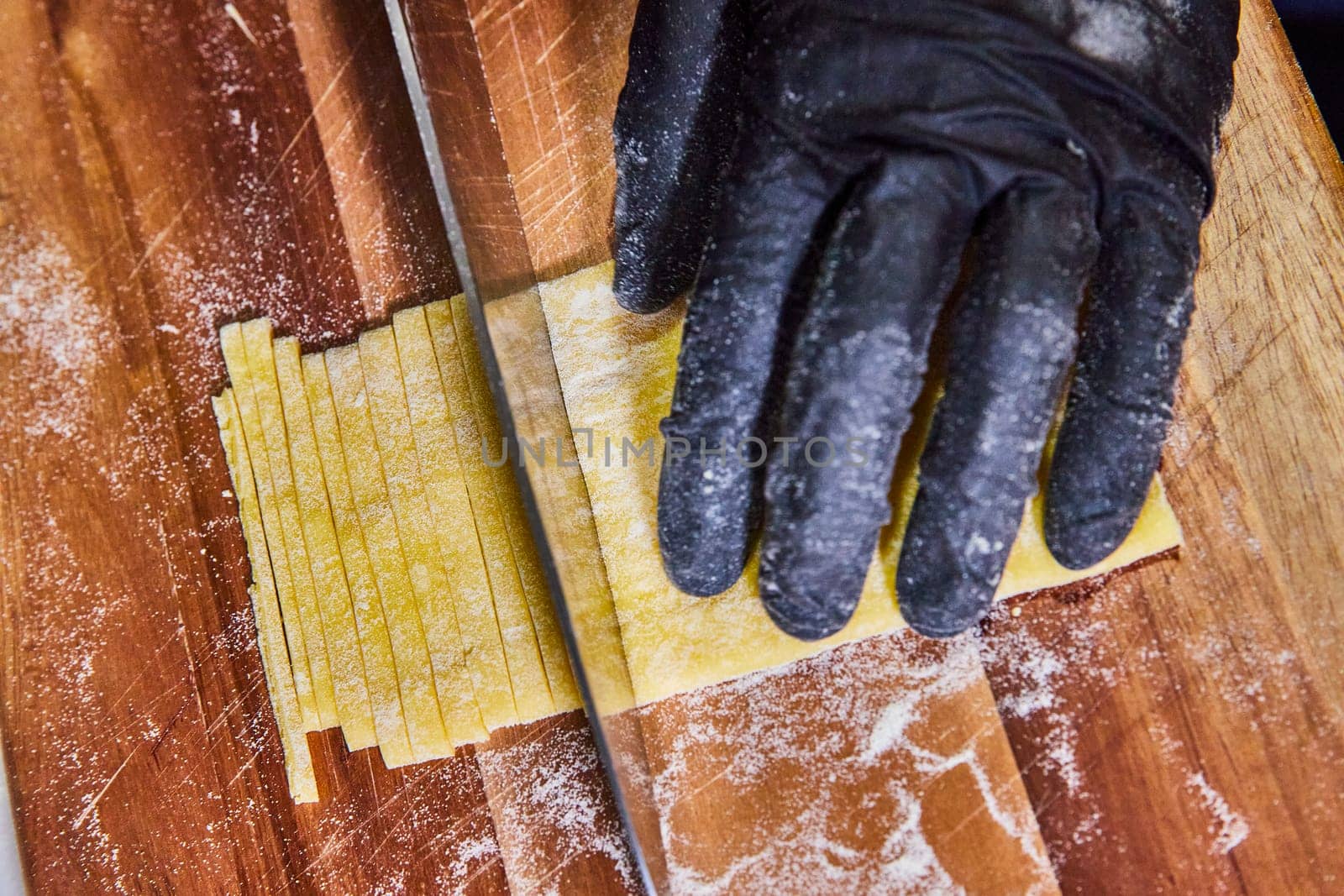 Artisanal Skill in Action: Close-up of Hand Cutting Fresh Homemade Pasta in a Kitchen in Fort Wayne, Indiana