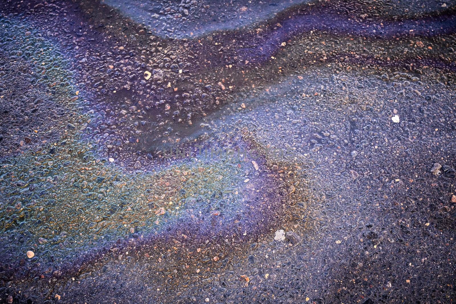 Textured stain of fuel or oil on wet asphalt on a rainy day. The concept of environmental pollution by AliaksandrFilimonau