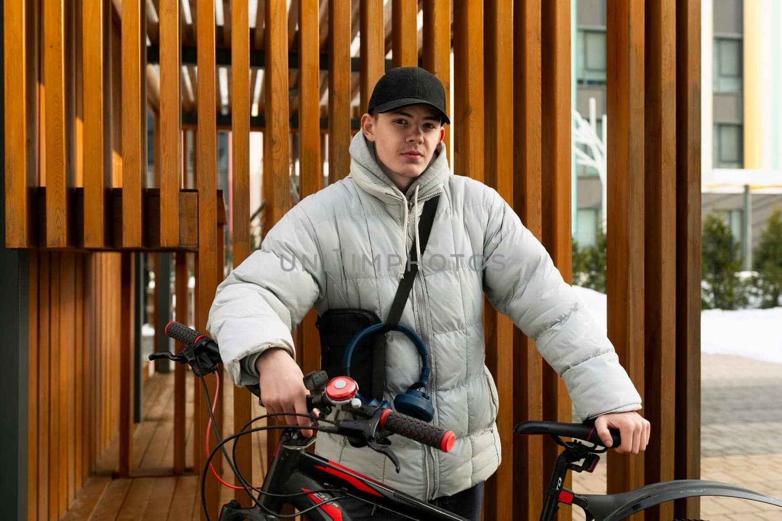 A young Caucasian man with a gray jacket and black cap rented a bicycle by TRMK