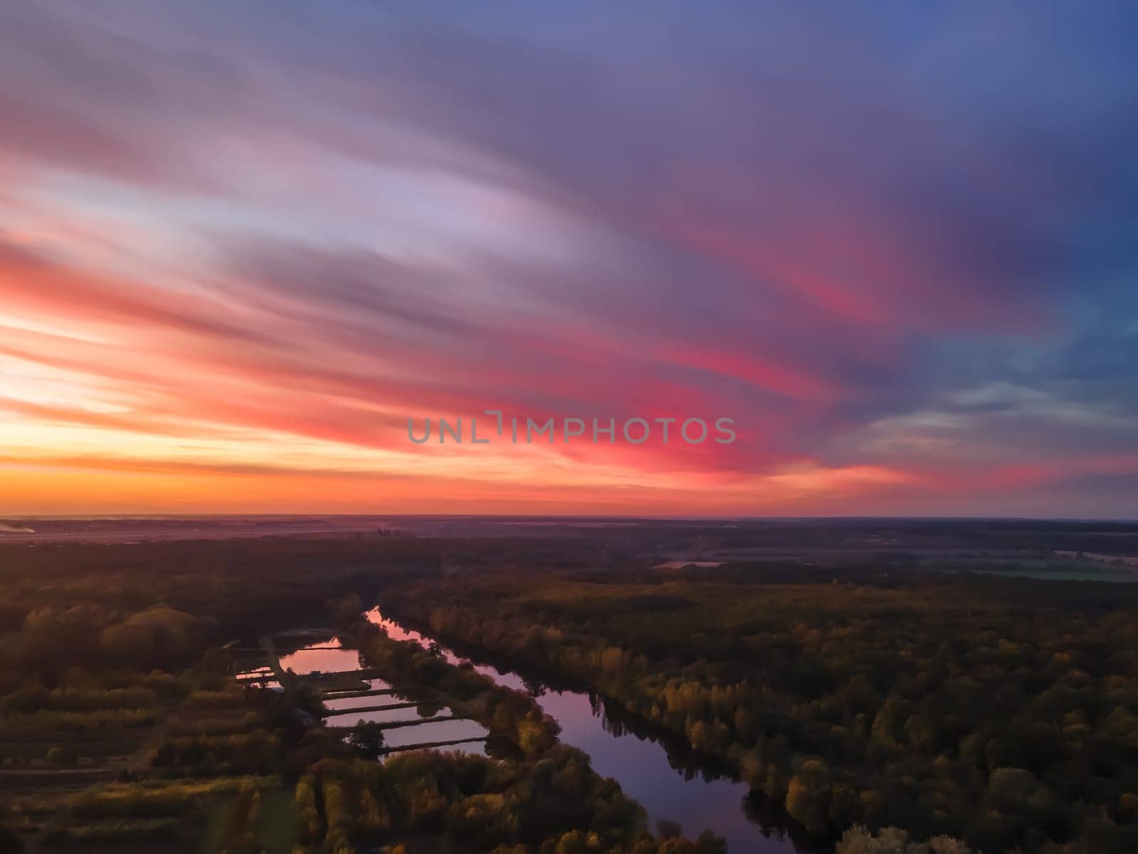 Aerial view of beautiful river and forest landscape with colorful summer skySunset along the banks of the river.