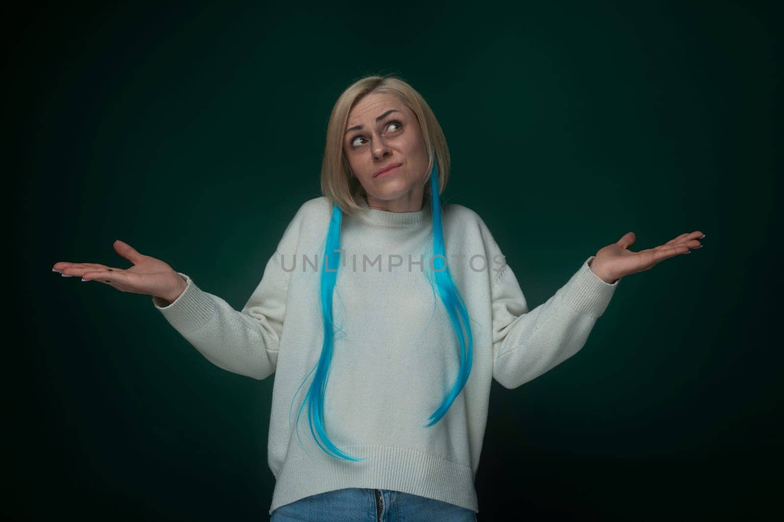 A woman with striking blue hair poses wearing a cozy white sweater. Her vibrant hair contrasts beautifully with the neutral tones of her outfit, creating a visually engaging look.