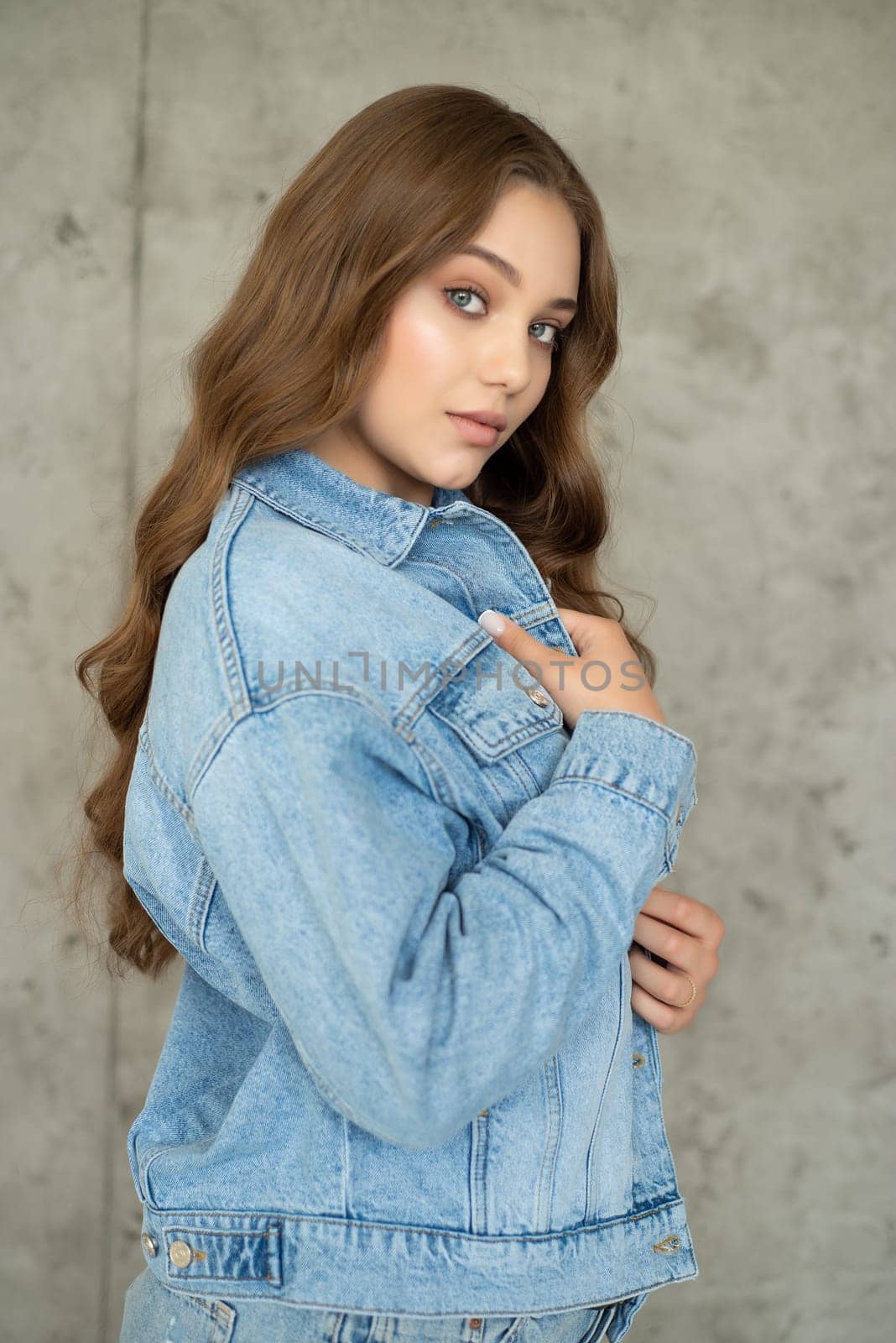 Woman in jeans jacket on studio background