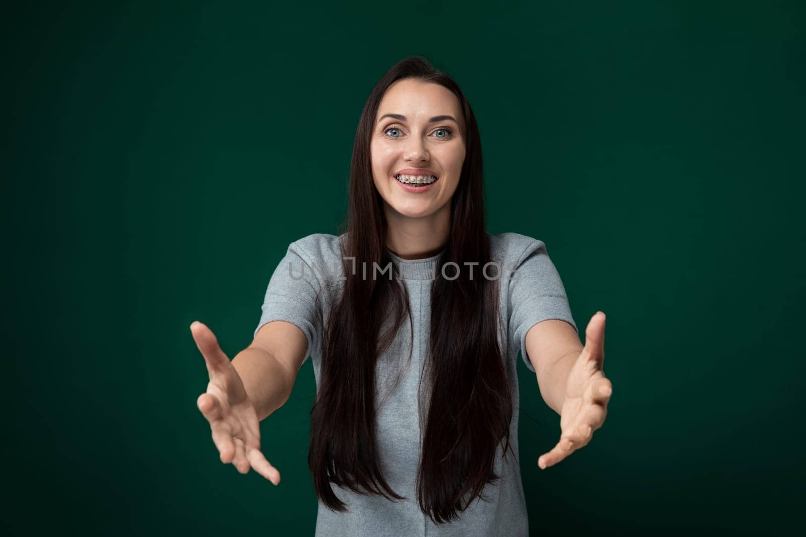 A woman with long black hair is smiling in the photograph. She appears happy and confident as she gazes at the camera with her bright smile. Her hair falls gracefully around her face, framing her joyful expression.