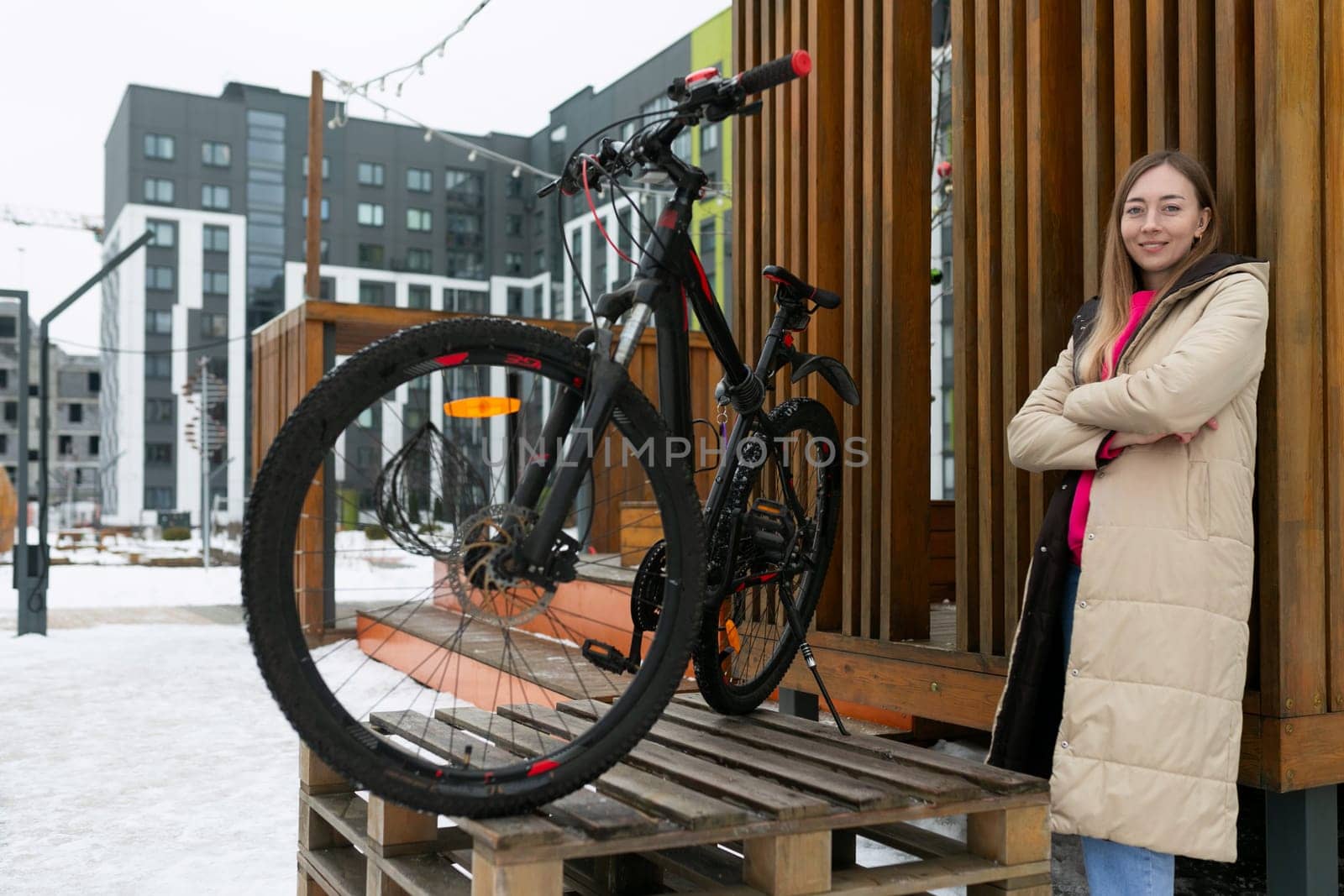 Woman Standing Next to Bike on Wooden Platform by TRMK