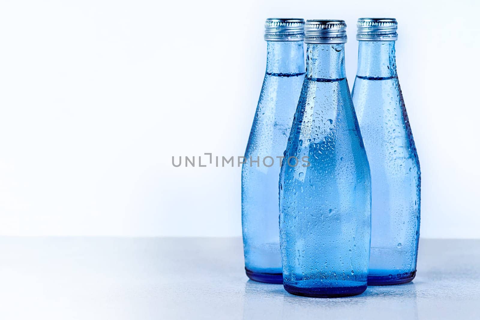 Bottles of water, studio and mineral liquid for aqua, cold drink and clear or pure tonic for diet. Natural, drink and beverage on white background for nutrition, h2o and collection for hydration by YuriArcurs