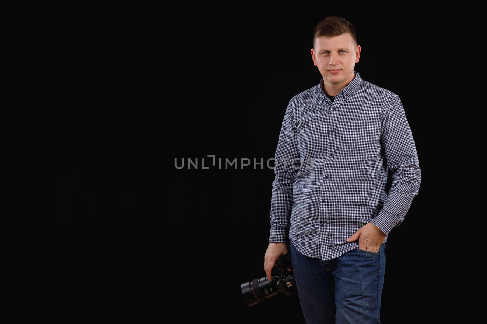 a photographer with a camera in his hands on a black background. High quality photo