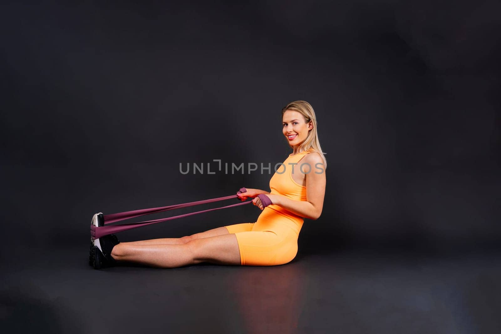 Athletic female performs exercises using resistance band. Strength and motivation