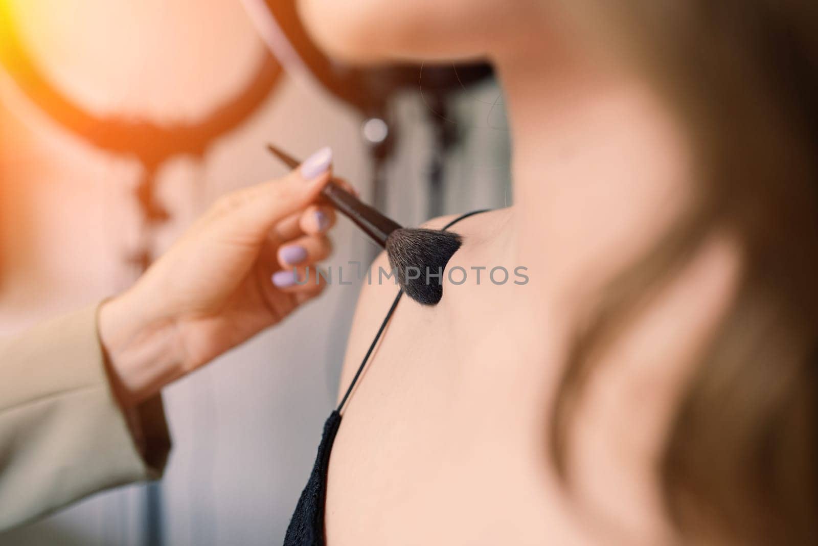 Woman make-up artist work in a studio with model