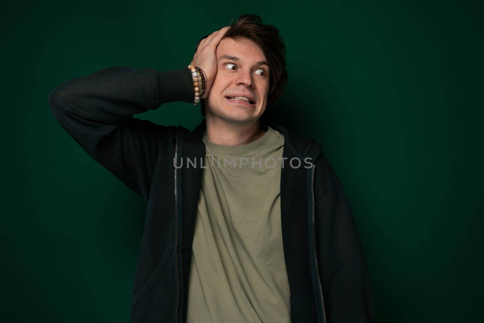 A man sitting with his head in his hands, appearing distressed and overwhelmed by emotions, possibly experiencing stress, sadness, or frustration.